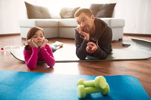 Padre e figlia si allenano a casa. Allenamento nell'appartamento. Fai sport a casa.