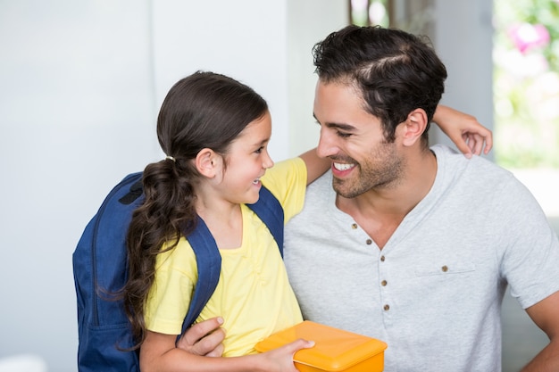 Padre e figlia sorridenti con la scatola di pranzo