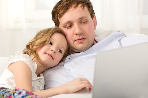 Padre e figlia usando il portatile