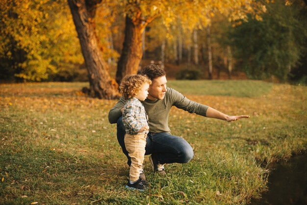 Padre e figlio ad esplorare la natura all'aperto nel parco al tramonto