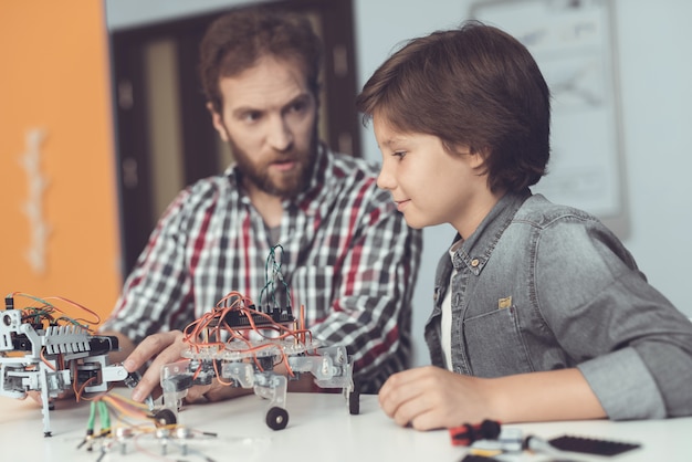 Padre e figlio barbuti che costruiscono robot a casa.