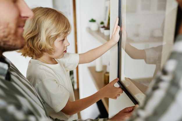 Padre e figlio che appendono insieme la foto