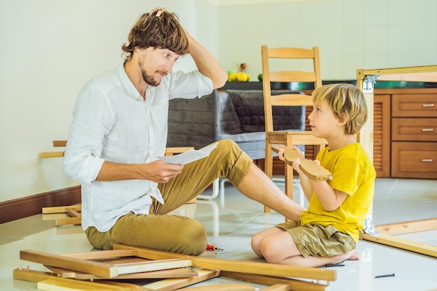 Padre e figlio che assemblano mobili Ragazzo che aiuta suo padre a casa Concetto di famiglia felice