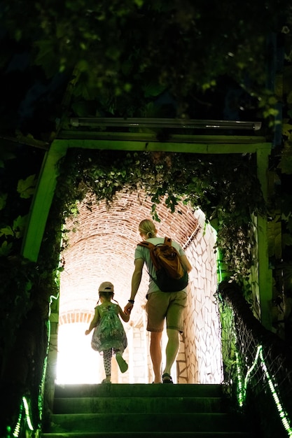 Padre e figlio che camminano attraverso il tunnel tenendosi per mano