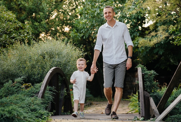 Padre e figlio che camminano nel parco al tramonto. Felicità. Amore