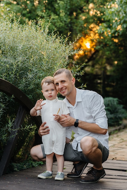 Padre e figlio che camminano nel parco al tramonto. Felicità. Amore