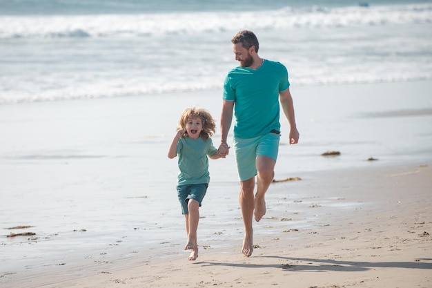 Padre e figlio che corrono sul concetto di mare di famiglia amichevole e di vacanze estive