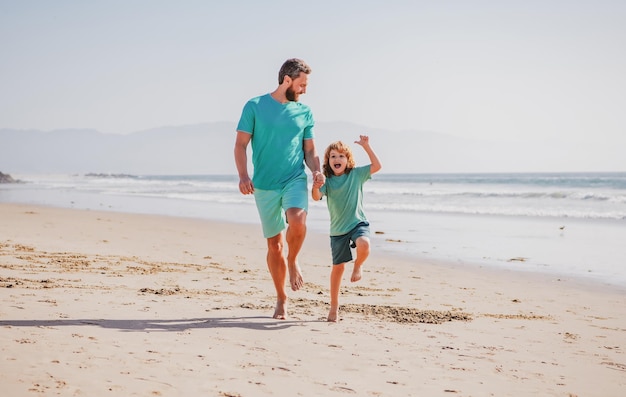 Padre e figlio che corrono sul concetto di mare di famiglia amichevole e di vacanze estive