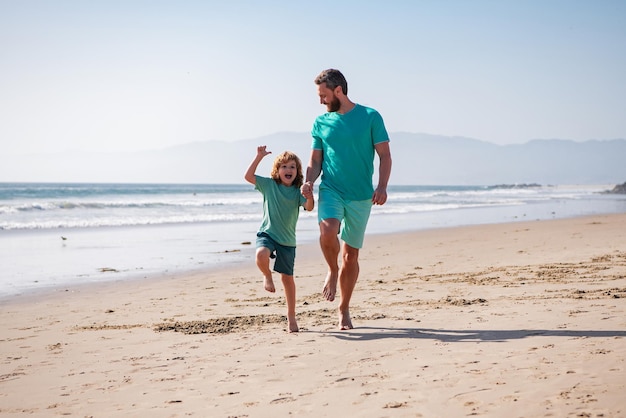 Padre e figlio che corrono sul concetto di mare di famiglia amichevole e di vacanze estive