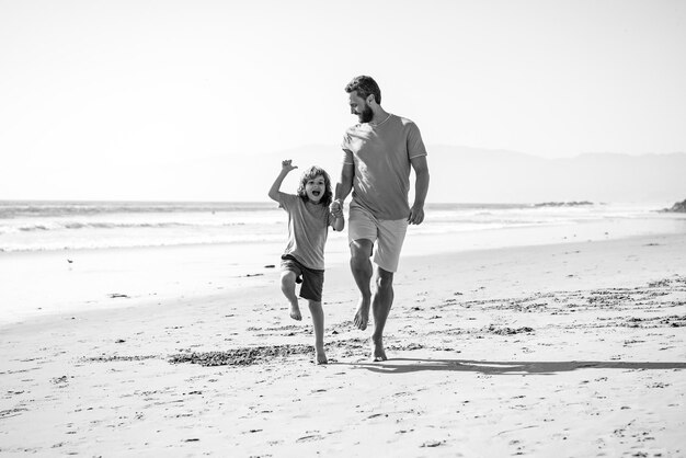 Padre e figlio che corrono sul mare concetto di famiglia amichevole e di vacanze estive