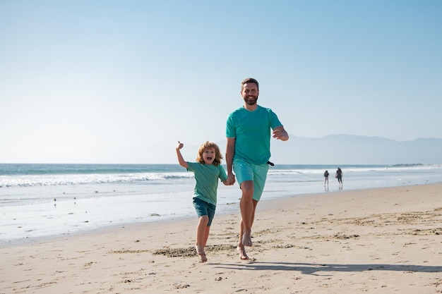 Padre e figlio che corrono sulla spiaggia estiva Concetto di festa del papà per le vacanze in famiglia