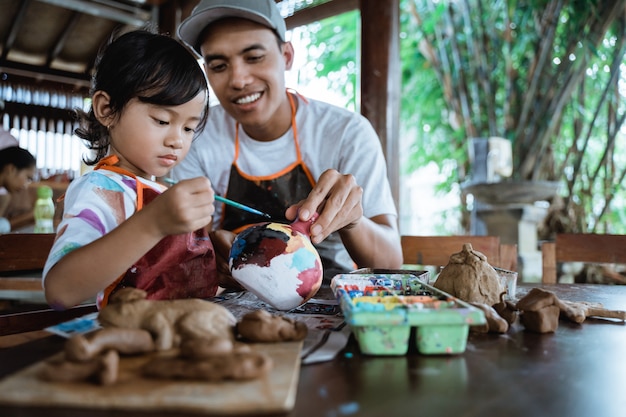 Padre e figlio che dipingono prodotti in ceramica