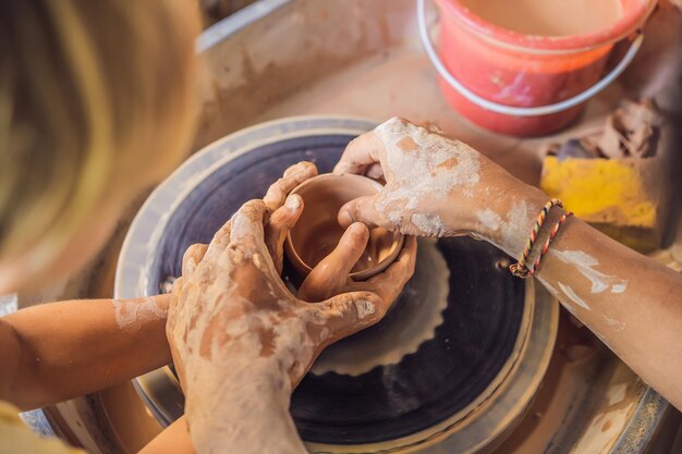 Padre e figlio che fanno vaso di ceramica nel laboratorio di ceramica