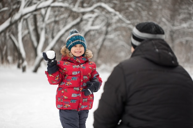 Padre e figlio che giocano a palle di neve in winter park