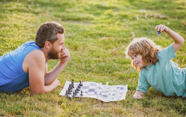 Padre e figlio che giocano a scacchi trascorrendo del tempo insieme nel parco.