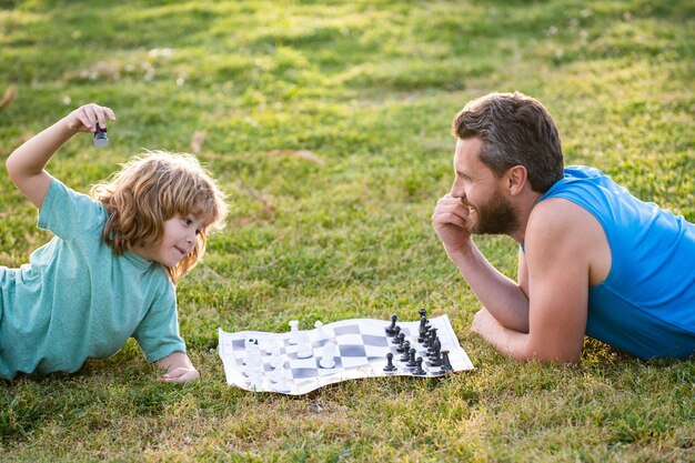 Padre e figlio che giocano a scacchi trascorrono del tempo insieme nel parco