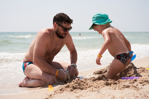 Padre e figlio che giocano con la sabbia