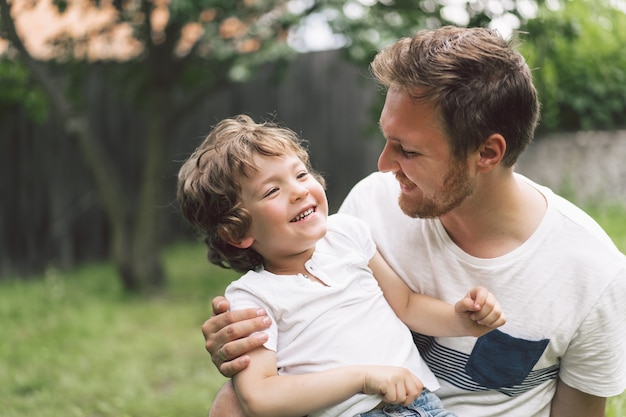 Padre e figlio che giocano e si abbracciano all'aperto