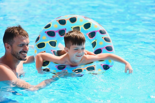 Padre e figlio che hanno divertimento in piscina.