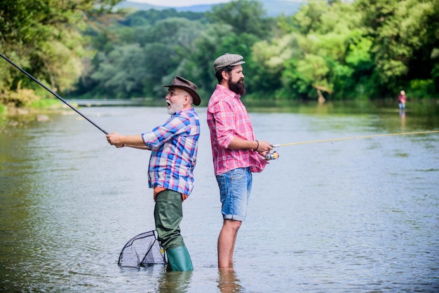 Padre e figlio che pescano Fine settimana estivo Attività pacifica Bella cattura Canna e paranco Attrezzatura da pesca per pescatori Nonno pescatore e amici uomini maturi Famiglia di pescatori Attività sportiva per hobby