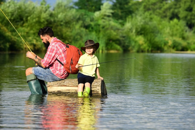 Padre e figlio che pescano in famiglia Tempo insieme Felice padre e figlio che pescano nel fiume con canne da pesca