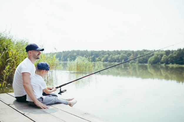 Padre e figlio che pescano sul lago, marito e figlio insieme a un picnic