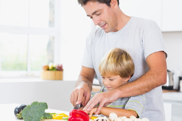 Padre e figlio che preparano insieme le verdure in cucina