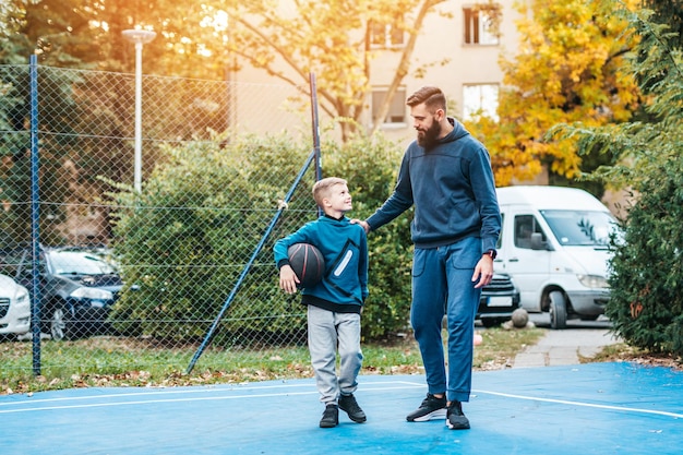 Padre e figlio che si divertono insieme sul campo da basket.