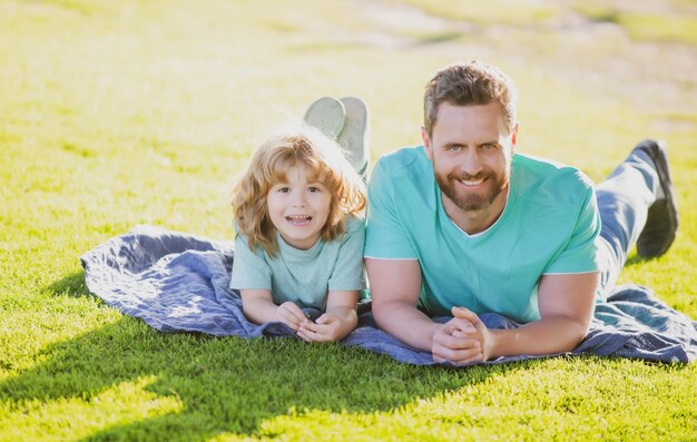 Padre e figlio che si rilassano sulla natura nel parco infanzia e genitorialità bambini concetto felice papà e bambino