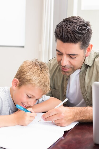 Padre e figlio che si siedono alla tabella che colora insieme