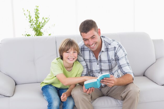 Padre e figlio con il libro di fiaba seduto sul divano