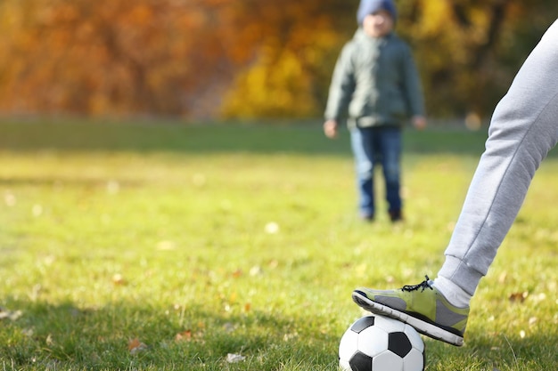 Padre e figlio con la palla sul campo da calcio vista ravvicinata