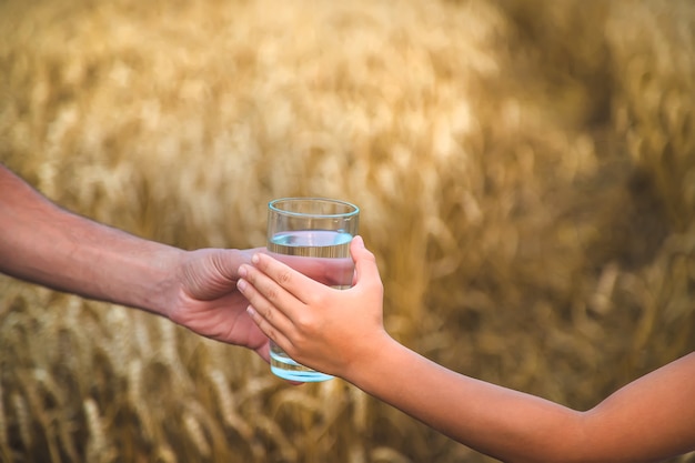 Padre e figlio con un bicchiere d'acqua. Messa a fuoco selettiva.