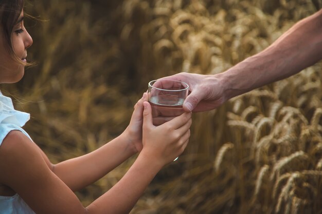 Padre e figlio con un bicchiere d'acqua. Messa a fuoco selettiva.