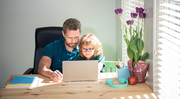 Padre e figlio concentrati con gli occhiali usano computer blog di famiglia ragazzo nerd fanno i compiti con l'insegnante webinar video lezione educazione online sul laptop homeschooling e elearning torna a scuola