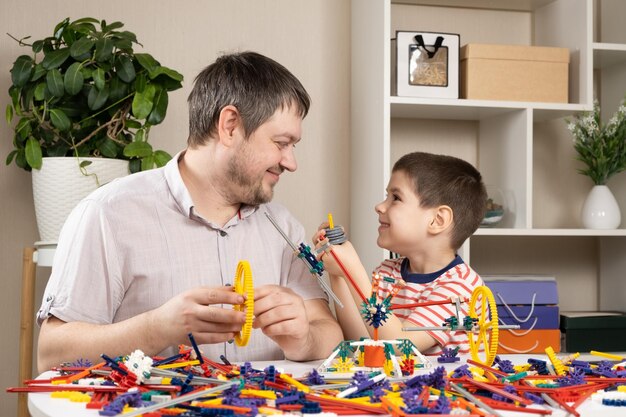 Padre e figlio costruiscono figure dal costruttore Passando del tempo insieme il ruolo del padre nella vita del figlio