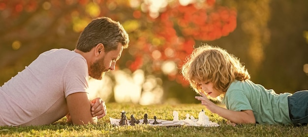 Padre e figlio giocano a scacchi banner poster all'aperto con copia spazio festa del papà felice famiglia genitorialità