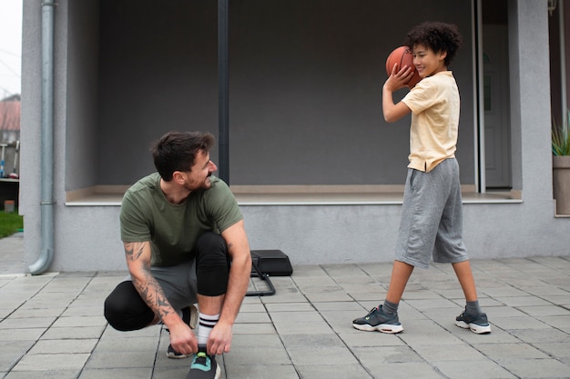 Padre e figlio giocano insieme a basket in giardino