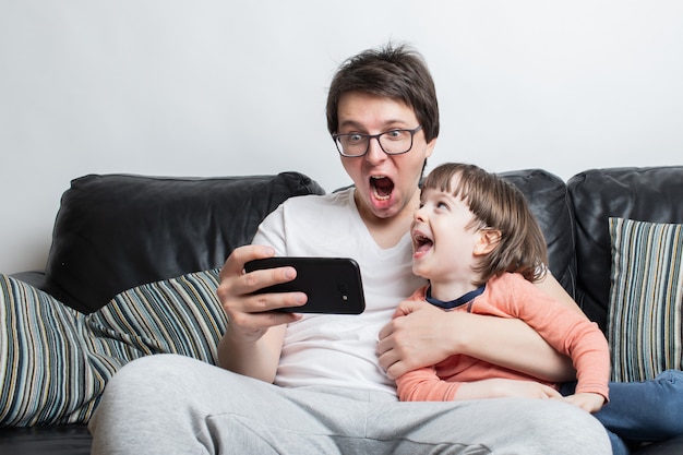 Padre e figlio guardando un video spaventoso al telefono.