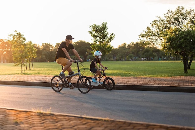 Padre e figlio in bicicletta nel parco