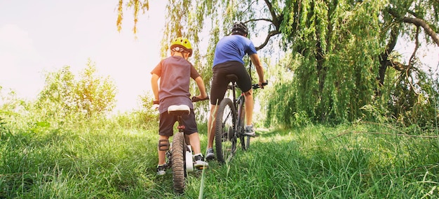 Padre e figlio insieme stanno andando in bicicletta attraverso il sentiero