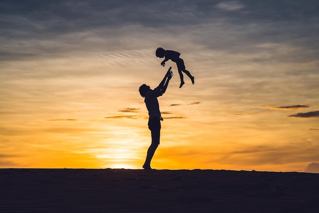 Padre e figlio nel deserto rosso all'alba in viaggio con il concetto di bambini