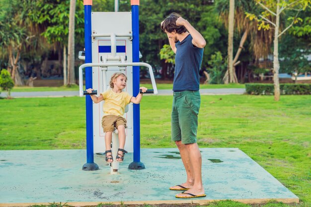 Padre e figlio nella palestra di strada nel parco