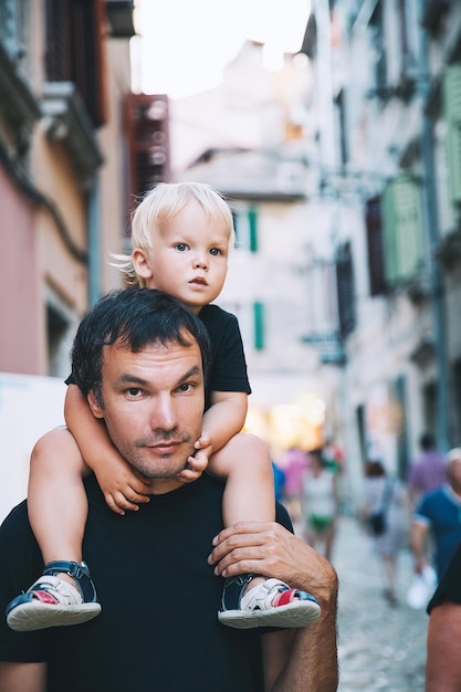 Padre e figlio nella vecchia strada di Rovigno Croazia Famiglia di turisti e vacanze estive L'uomo con il suo bambino è un viaggiatore ed esploratore Europa