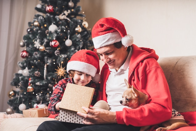 Padre e figlio ragazzo regalo di Natale aperto a casa.