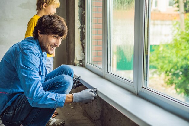 Padre e figlio riparano le finestre insieme. Ripara la casa da solo.