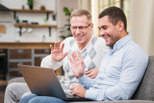 Padre e figlio salutando qualcuno in videochiamata