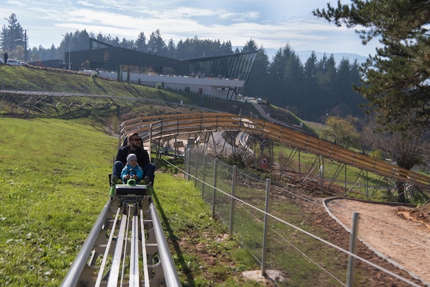 padre e figlio si divertono a guidare sulle montagne russe alpine