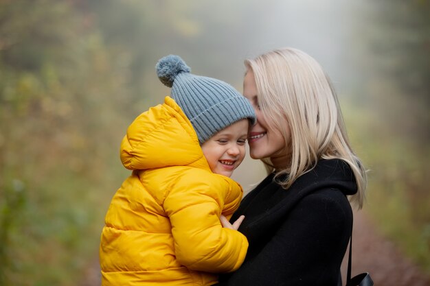 Padre e figlio si divertono nella foresta d'autunno nella nebbia