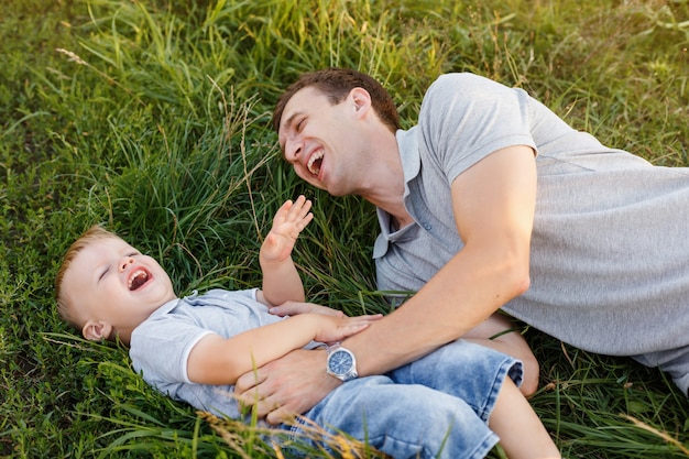 Padre e figlio si fanno il solletico sull'erba